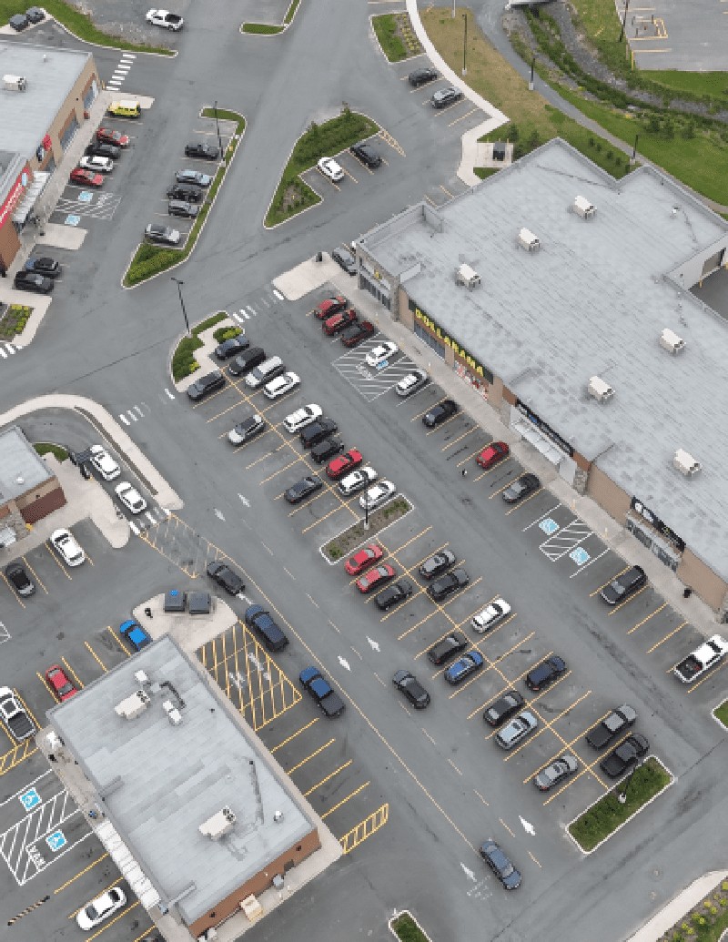 New Project (5) Aerial view of a commercial area with parking, a roundabout, and several buildings